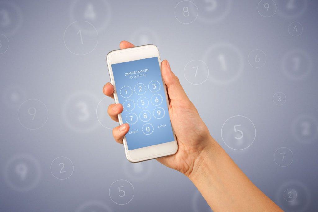 A hand holds a smartphone displaying a lock screen with a numeric keypad for entering a passcode, against a blurred background with floating numbers.